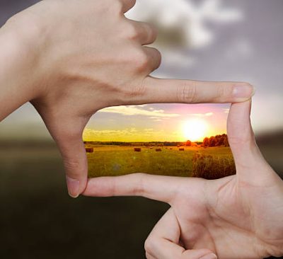 out of focus nature and fingers creating a square making the scenery better